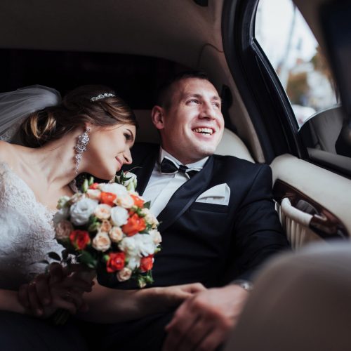 young couple in a car in wedding day